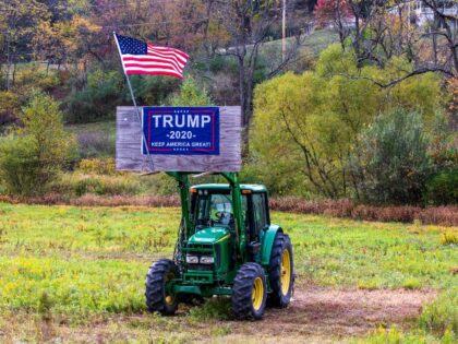 John Deere tractor with flag and Trump sign