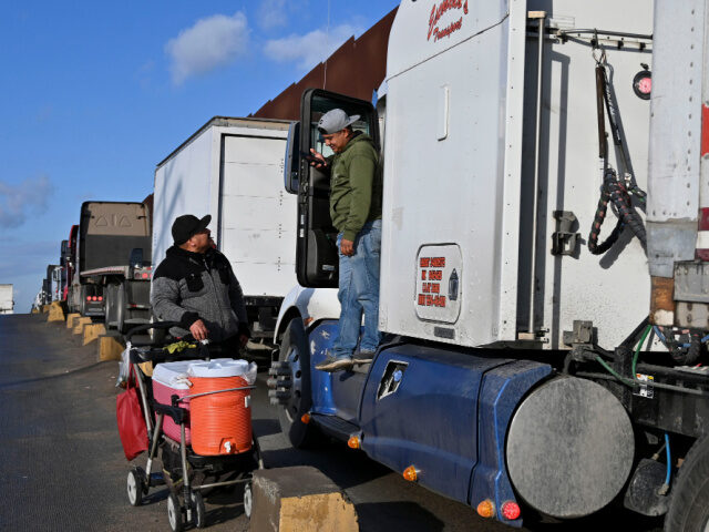 A vendor sells drinks to truck drivers as they wait in line at the Otay Mesa Port of Entry