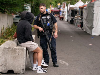 A police officer talks to people while responding to a mass shooting at the Bite of Seattl