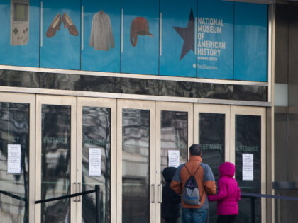 Visitors look at signs at the entrance of the Smithsonian National Museum of American Hist