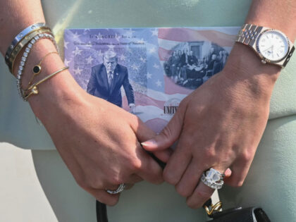 Bettina Trump, wife of Donald Trump Jr., holds a design of a US passport featuring an imag