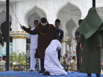 An Indonesian woman is whipped in public in Banda Aceh on March 4, 2019. Six couples were
