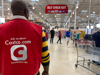 Costco employee helps monitor customers at Self Check-out kiosks in Florida in March 2024.