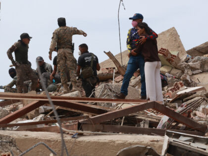A man embraces a woman amid the rubble of a collapsed building following the earthquake in