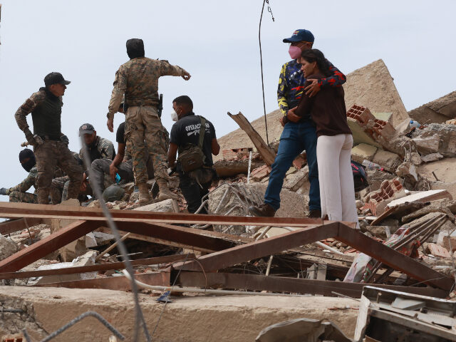 A man embraces a woman amid the rubble of a collapsed building following the earthquake in