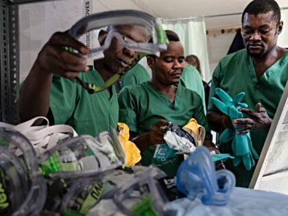 Health workers prepare to kit themselves in Personal Protective Equipment (PPE) during a t