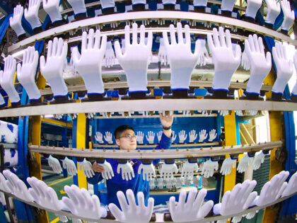 GAOMI, CHINA - OCTOBER 12: An employee works on the production line of protective gloves a