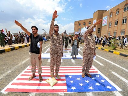 Men gesture as they express their affiliation and support for the Houthi movement while st