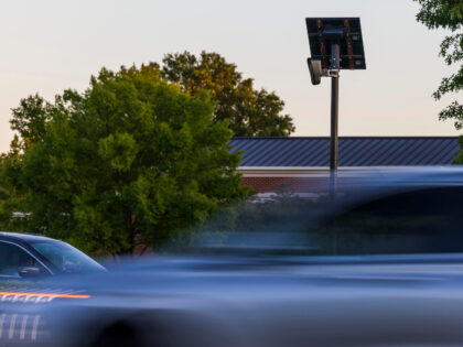 Cars drive by a Flock Camera, an automated license plate reader, on East Little Creek Road