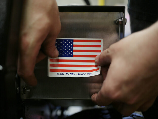 A worker puts a "Made in the USA" sticker on the back of a completed lawnmower at the Dixi