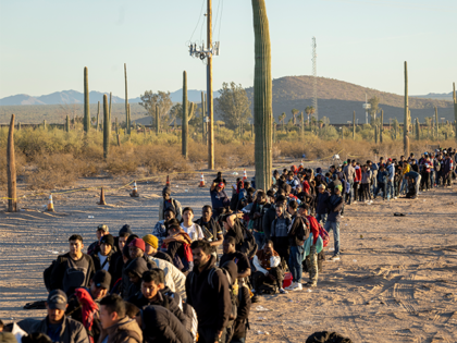 Migrants line up at a remote U.S. Border Patrol processing center after crossing the U.S.-