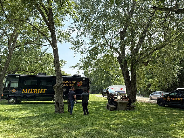 Officials stand at a staging area after an operation to recover multiple people who died w