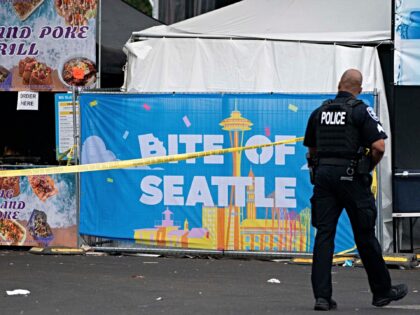 SEATTLE, WASHINGTON - JULY 26: A police officer walks by police tape and a sign for the Bi