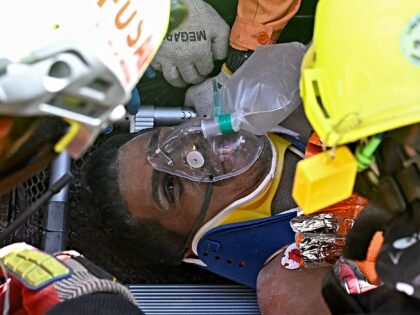 Hernan Gil, a survivor of Venezuela's twin earthquakes, is assisted by members of internat