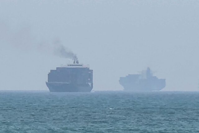 Cargo ships are seen anchored Sunday near the Strait of Hormuz, off the eastern coast of t