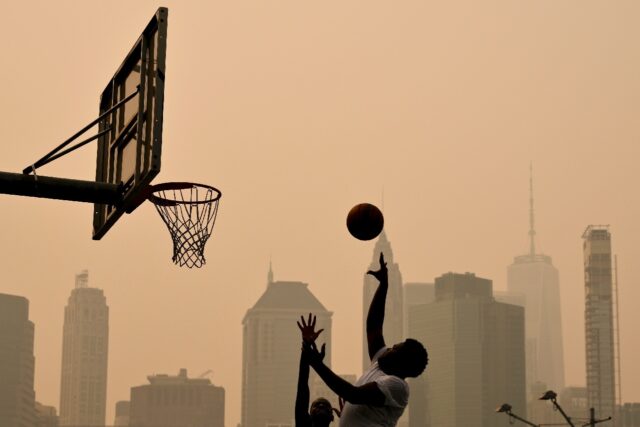 People play basketball as wildfire smoke from Canada causes hazy conditions in New York
