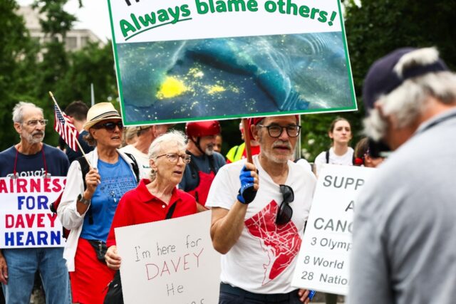 Protestors march before former Olympian David Hearn's arraignment in Washington for a
