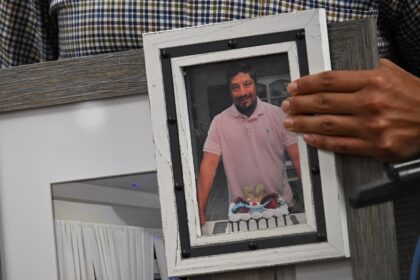 Ronaldo Salgado holds a portrait of his father at a press conference asking for a probe in