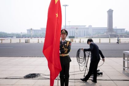 A soldier waits to unfurl a Chinese flag at the Great Hall of the People in Beijing