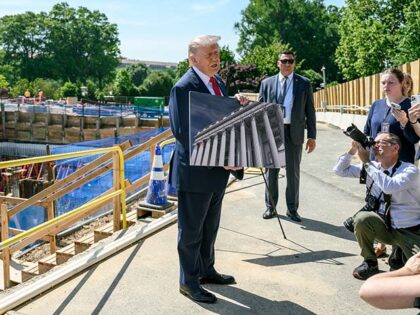 President Donald J. Trump speaks with members of the media next to the ongoing constructio