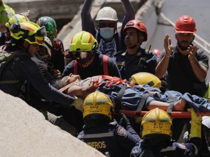 Rescue workers carry Diana Troncoso after pulling her from the rubble the day after an ear