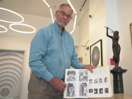 Art dealer Bill DeLind shows a picture of a Pablo Picasso sketch (upper left) stolen from