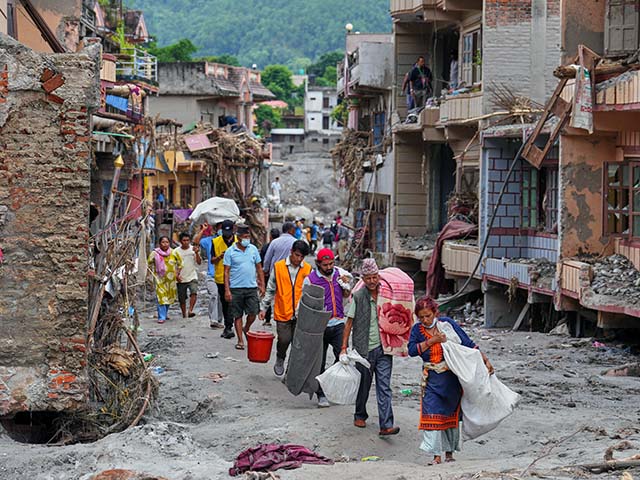 Title: Photos show aftermath of flash floods in Nepal Image ID: 26241298155448 Article: Residents carry their belongings salvaged from their damaged homes filled with mud and debris in Devighat, in Nepal's Nuwakot district, Saturday, Aug. 29, 2026, following the Aug. 26 flash floods. (AP Photo/Rajesh Kumar Singh)