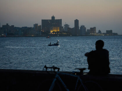 A man sits on the Malecón seawall after sunset during a blackout in Havana, Cuba, Tuesday