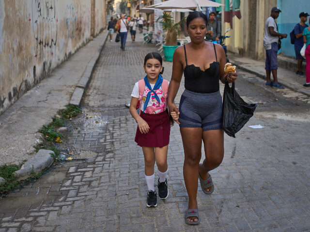 A woman accompanies a student to school in Havana, Cuba, Friday, March 13, 2026. Ramon Esp