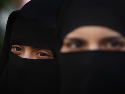 LONDON, ENGLAND - APRIL 11: Two women wearing Islamic niqab veils stand outside the French