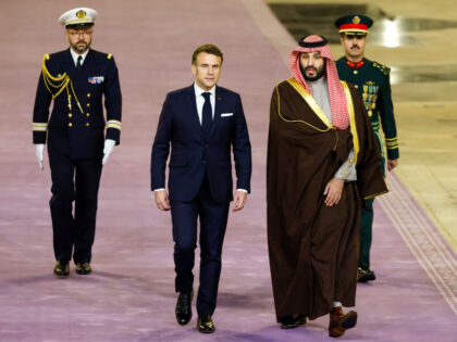 French President Emmanuel Macron (C) walks next to Saudi's Crown Prince Mohammed Bin
