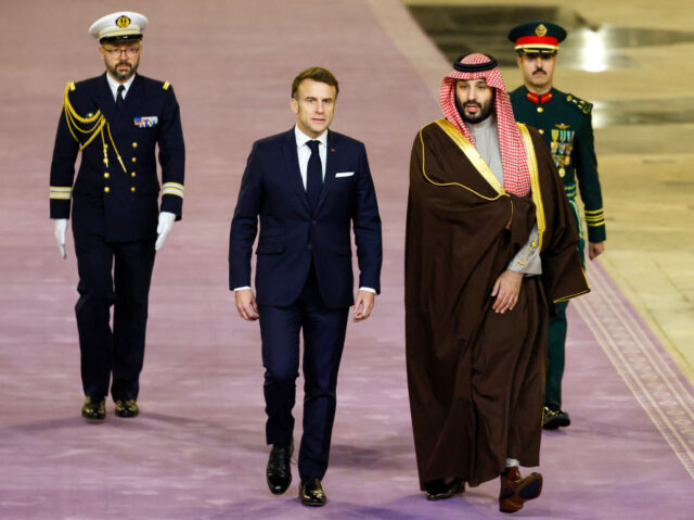 French President Emmanuel Macron (C) walks next to Saudi's Crown Prince Mohammed Bin