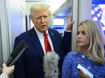 US President Donald Trump, watched by White House Press Secretary Karoline Leavitt, speaks