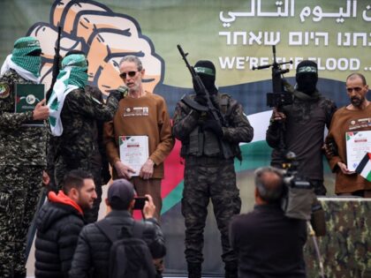 Palestinian Hamas fighters escort Israeli hostages before handing them over to a Red Cross