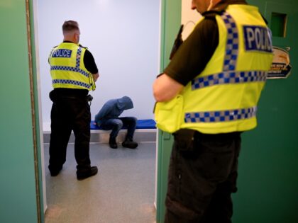 POOLE, ENGLAND - JUNE 7: In this photo illustration, a police officer watches over a priso