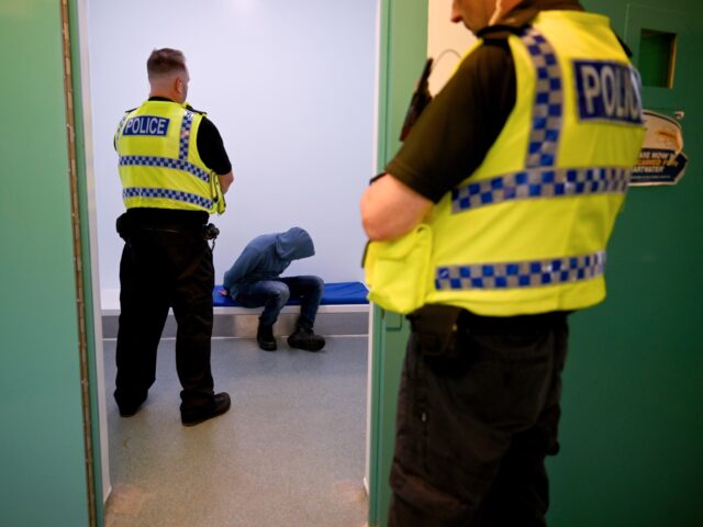 POOLE, ENGLAND - JUNE 7: In this photo illustration, a police officer watches over a priso