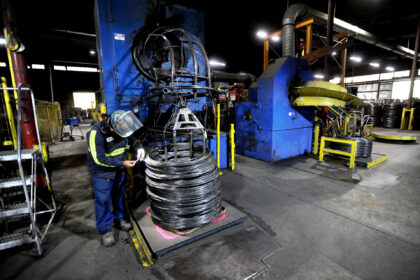 WALLINGFORD, CT - OCTOBER 13: Miguel Aguirre checks the thickness of drawn wire while it s