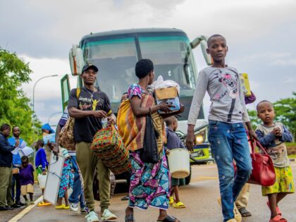 Burundian refugees to be repatriated disembark a bus at the Nemba-Gasenyi border post betw