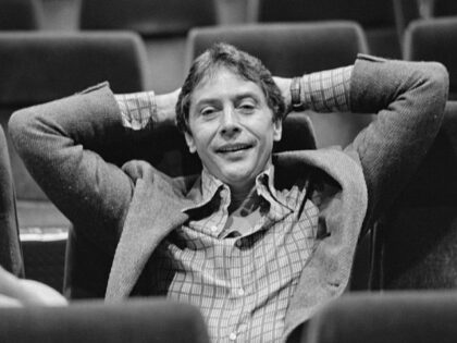 American film director and actor Mark Rydell, wearing a blazer over a checked shirt, his h