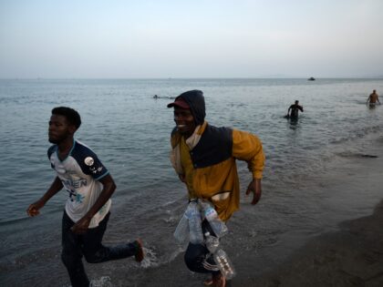 TOPSHOT - Migrants arrive on the shore after swimming into the Spanish enclave of Ceuta in