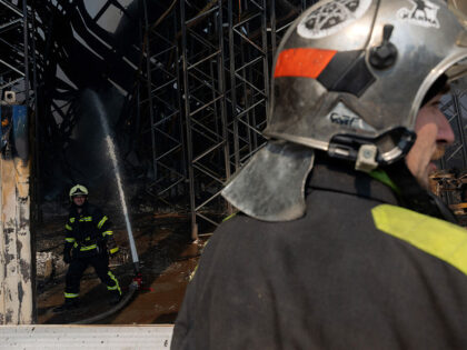 Ukrainian firefighters work to put out a fire following massive Russian ballistic missile
