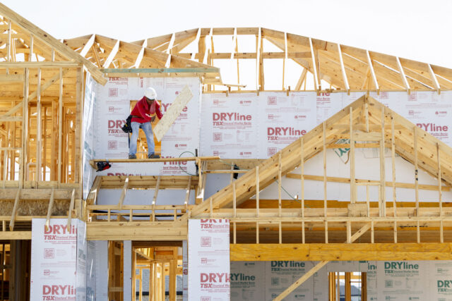 A construction worker on a new home under construction at the Taylor Morrison Avalon at Cy