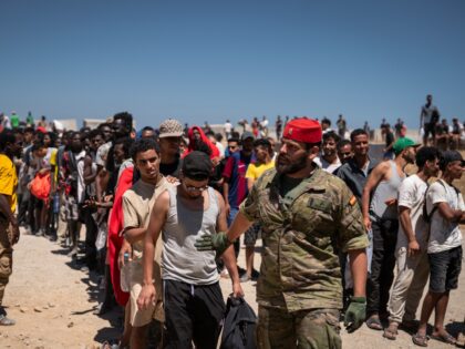 CEUTA, SPAIN - AUGUST 2: Migrants wait to receive water on the beach next to the CETI (Cen