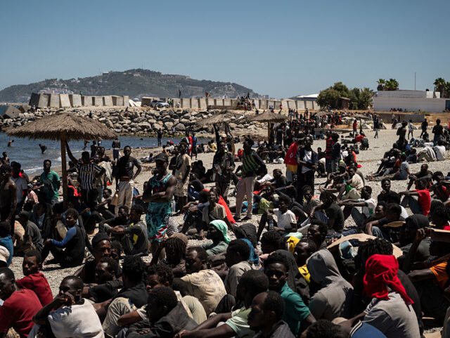 CEUTA, SPAIN - AUGUST 2: Migrants wait on the beach next to the CETI (Centros de Estancia