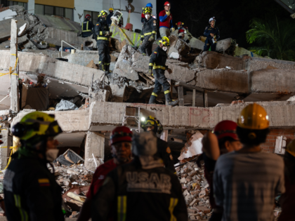 Rescue workers remove rubble from the Cantabria building following the earthquake in Cali,