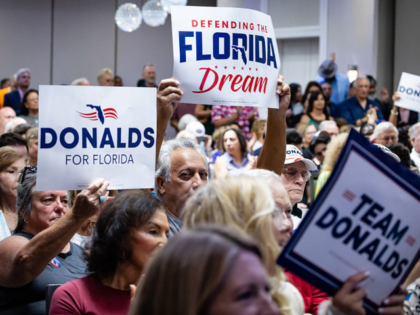 Attendees hold campaign signs during a "Get Out The Vote" rally with Representative Byron