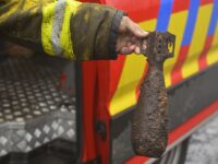 A firefighter holds a shell he found from World War II as he takes part operations against a wildfire at the Hautes Fagnes (High Fens) nature reserve near Waimes, eastern Belgium, on August 18, 2026. Rain started falling in Belgium on August 17, 2026 to help its fight against the country's biggest modern-day wildfire that has devastated some 3,000 hectares (7,500 acres) of the High Fens park on the border with Germany. Some 500 firefighters and troops are battling the blaze that has sent a huge cloud of black smoke across the region into neighbouring Germany and France. Scientists have long warned that climate change caused by human use of fossil fuels will make periods of drought more intense and longer-lasting, creating the ideal conditions for wildfires. (Photo by JOHN THYS / AFP via Getty Images)