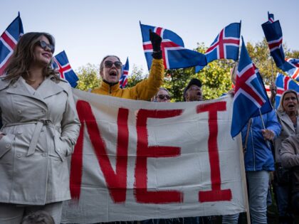 Supporters of the 'No' campaign display a banner during a rally against reopening Iceland'