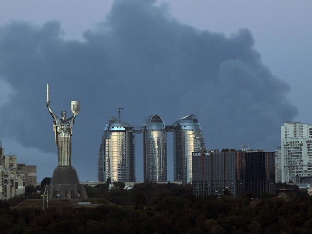 A plume of smoke from a fire in a Kyiv suburb rises behind the Motherland Monument and apa
