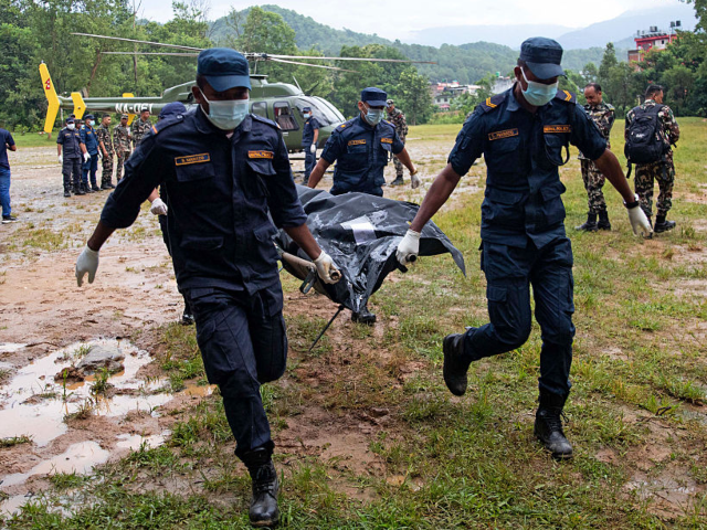GettyImages-2291873116 Nepali Army personnel carry bodies of deceased victims during rescue operations after flas